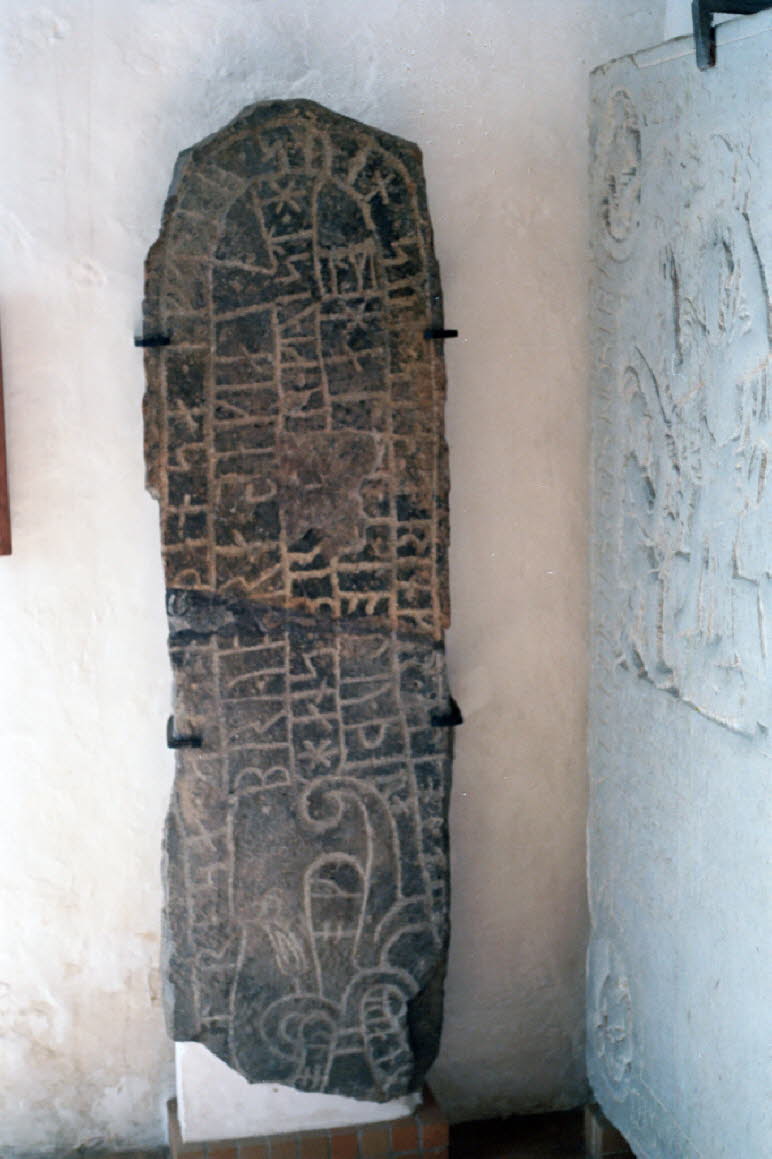 Auf der Insel Bornholm gibt es die meisten Bautasteine und Runensteine in ganz Dänemark. Umstände des Runensteines: Der Stein wurde erstmals 1842 erwähnt. Er befand sich damals in einer Luke im Kirchturm, teilweise versteckt. Das Fragment wurde erstmals 1K