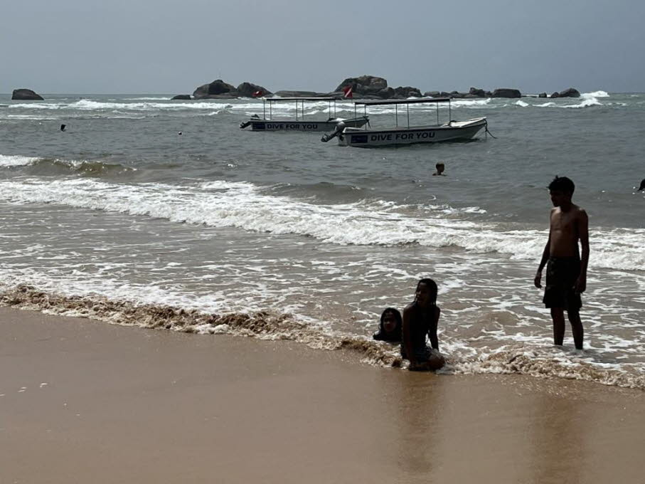Hikkaduwa 2025: Vor der gleichen Felsengruppe baden Einheimische und Touristen gleichermaßen.