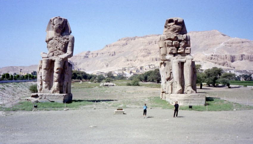 Memnon Kolosse 2000: Die Memnonkolosse: Das Paar königlicher Kolosse stehen vor dem zerstörten Amon-Re geweihten Haupttempel. Ihm gingen drei große Ziegelmasten voraus, denen jeweils ein Paar königlicher Kolosse vorausgingen, die den Zugang zu drei Höfen 
