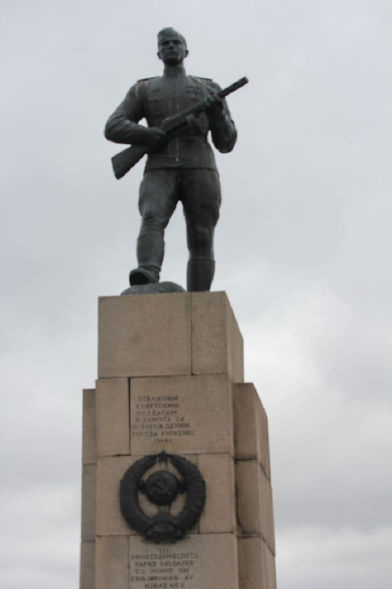 Ein Denkmal an der Nordseite der Friedhofsmauer aus schwarzem Stein zeigt einen sowjetischen Soldaten mit einem roten Stern. Es erinnert an die Befreiuung von Kirkenes durch die Sowjetarmee.  Der Atlantikwall sollte vor einer alliierten Invasion schützen.